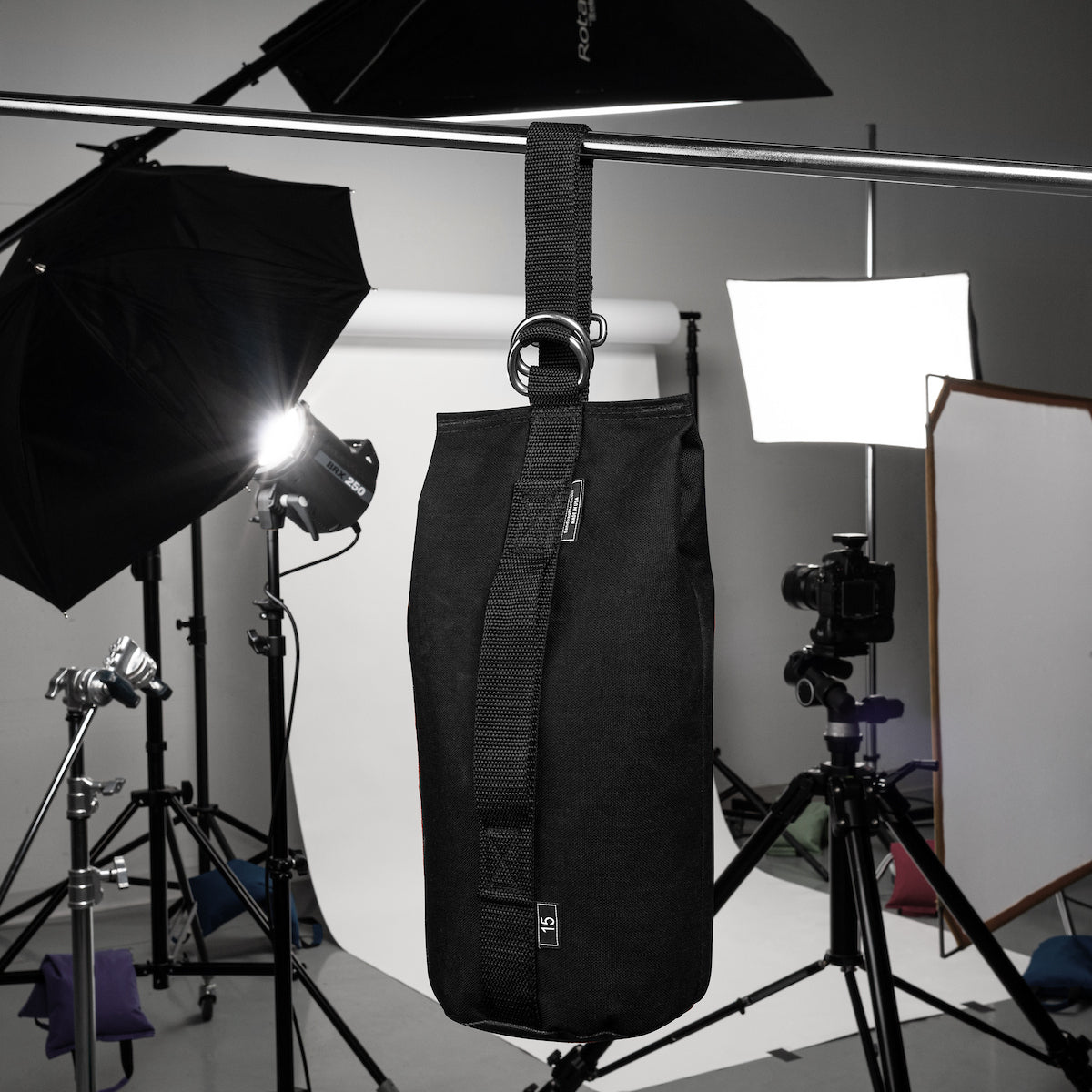 Black bag hanging in a photography studio with lighting equipment.