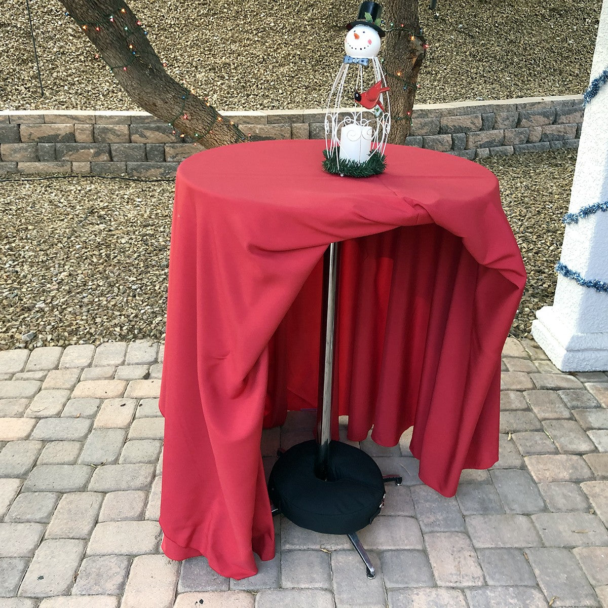 Circular sandbag used to add stability to a portable table in an outdoor residential setting