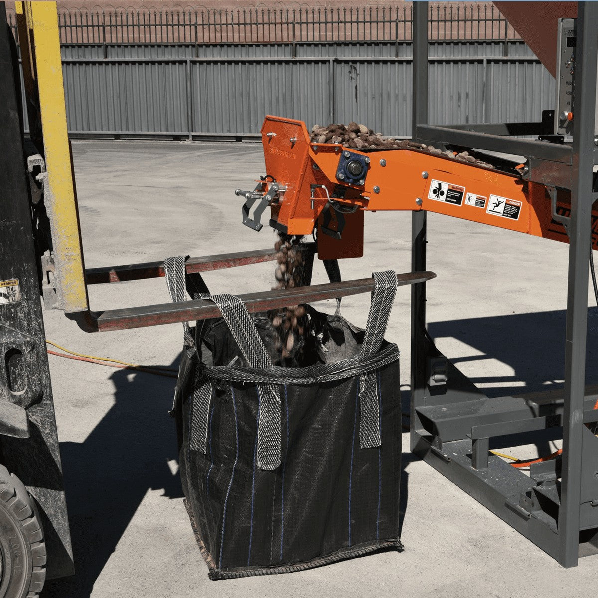 Ultimate Bagger sandbag filling machine being used to fill FIBC Bulk Bags with 3 inch river rock with 2500 lb dispensments
