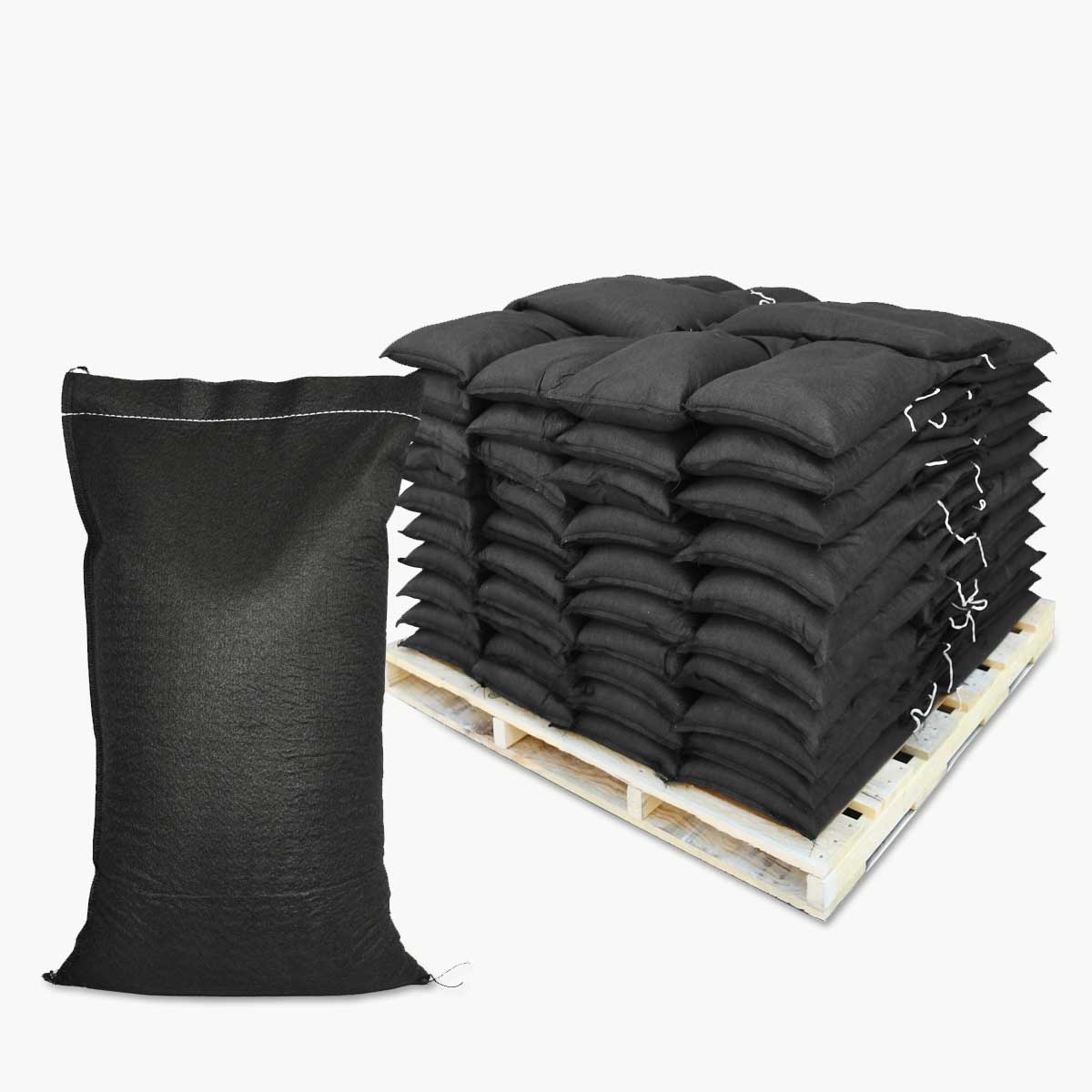 Pallet of black geotextile sandbags in the background and a single filled geotextile sandbag in the foreground on a white backdrop